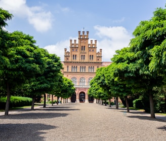 a large building surrounded by trees on a sunny day