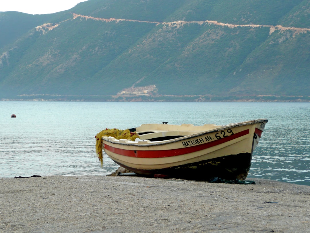 white and red boat on body of water