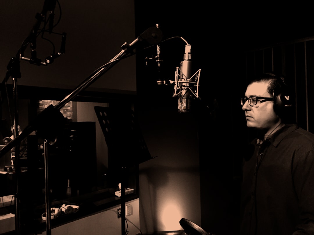man standing in front of condenser microphone inside recording studio, Emiliano Cadena singer