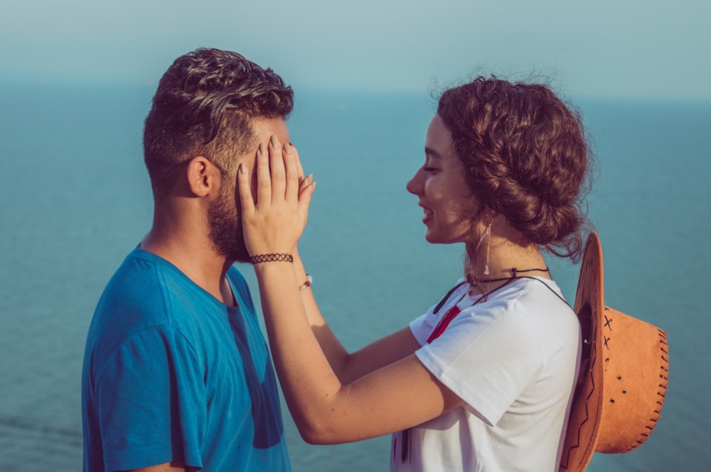 woman covering man's face