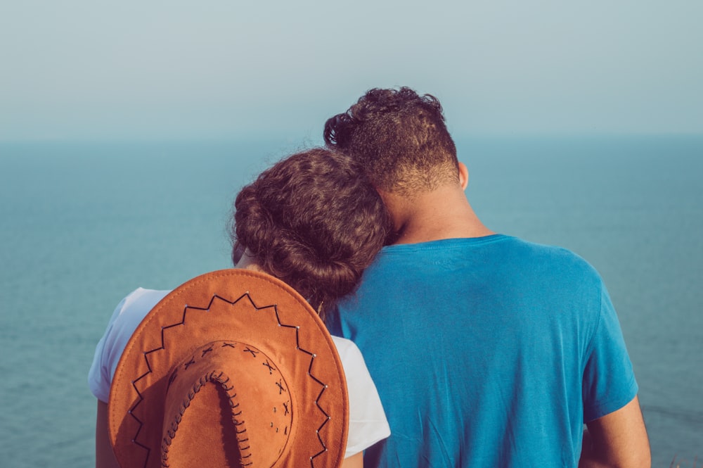 man and woman standing together facing sea