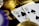 A close-up view of playing cards, specifically a Queen and a Ten of spades, surrounded by shiny gold coins and part of a poker chip, suggesting a gambling or casino theme.