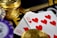 A close-up view of playing cards showing the ten of hearts placed alongside poker chips and a stack of gold coins. The scene suggests a gambling or casino setting with high stakes involved.