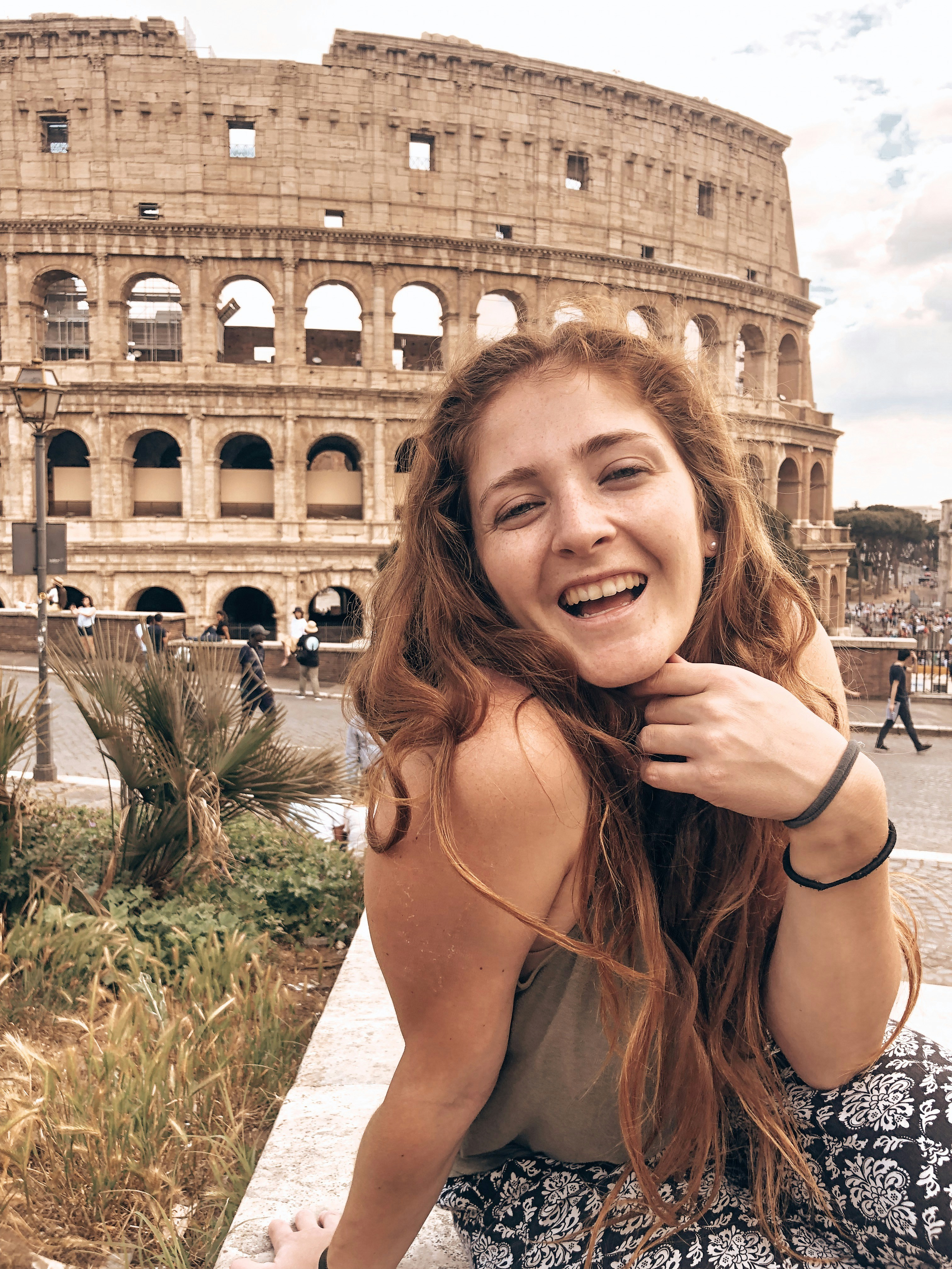 woman smiling near coliseum