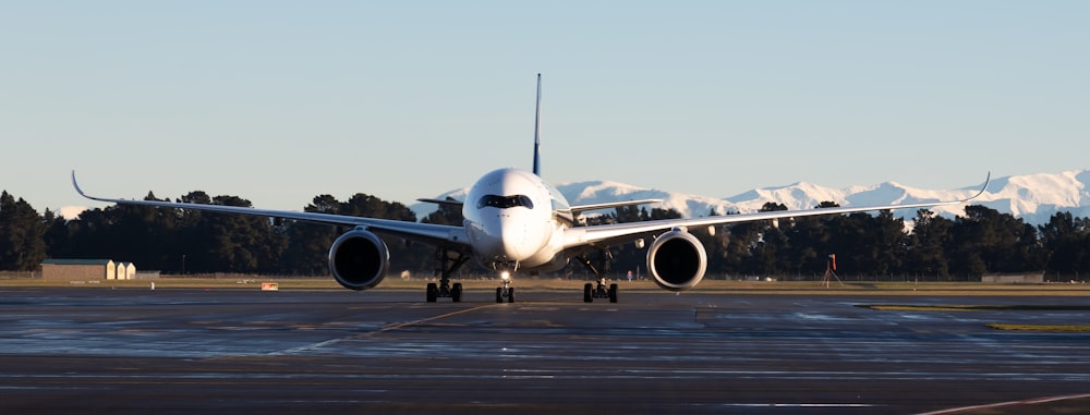 avion de ligne blanc sur la piste pendant la journée