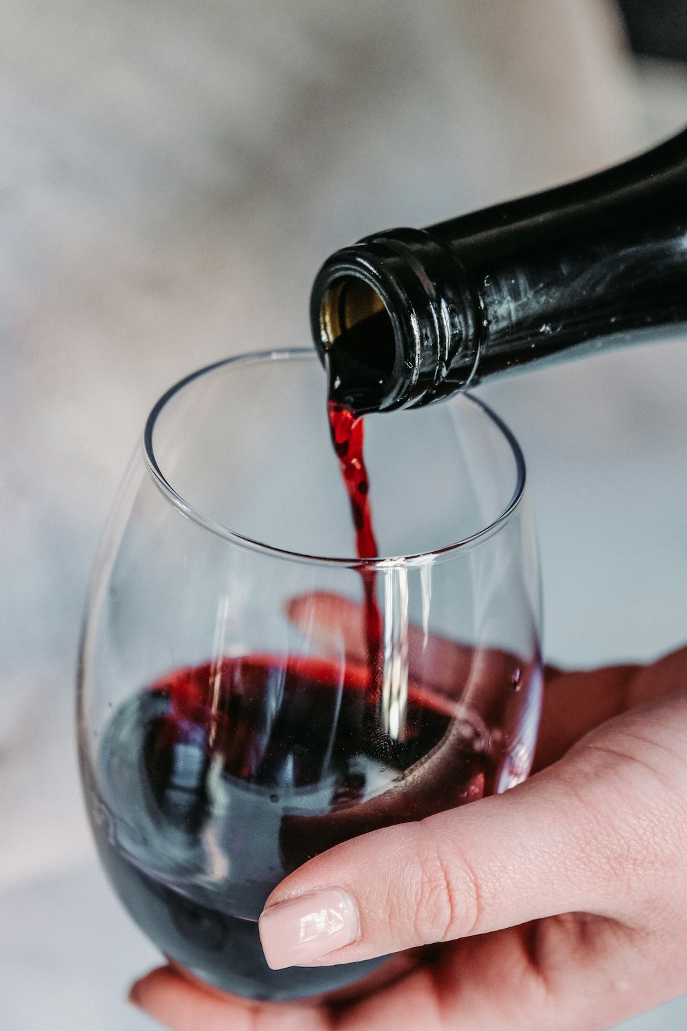 Het schenken van rode wijn in een glas
