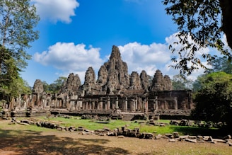 A serene ancient temple surrounded by lush greenery under a clear blue sky.