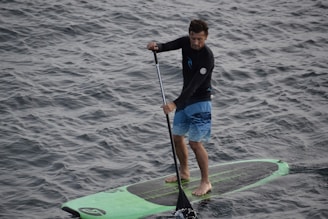 man on surf board with paddle