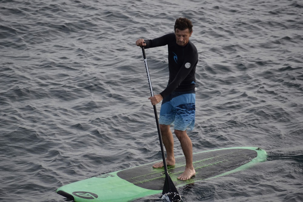 man on surf board with paddle