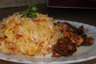 A sizzling platter of fried rice with chunks of chicken and vibrant mixed vegetables