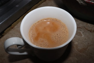 A vibrant mug filled with coffee, featuring a sleek printvibe logo on a marble countertop.