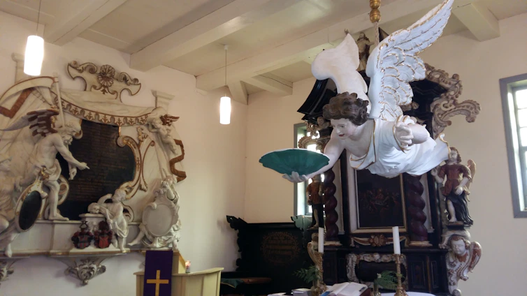 A serene chapel interior bathed in soft light with a statue of the Immaculate Conception.