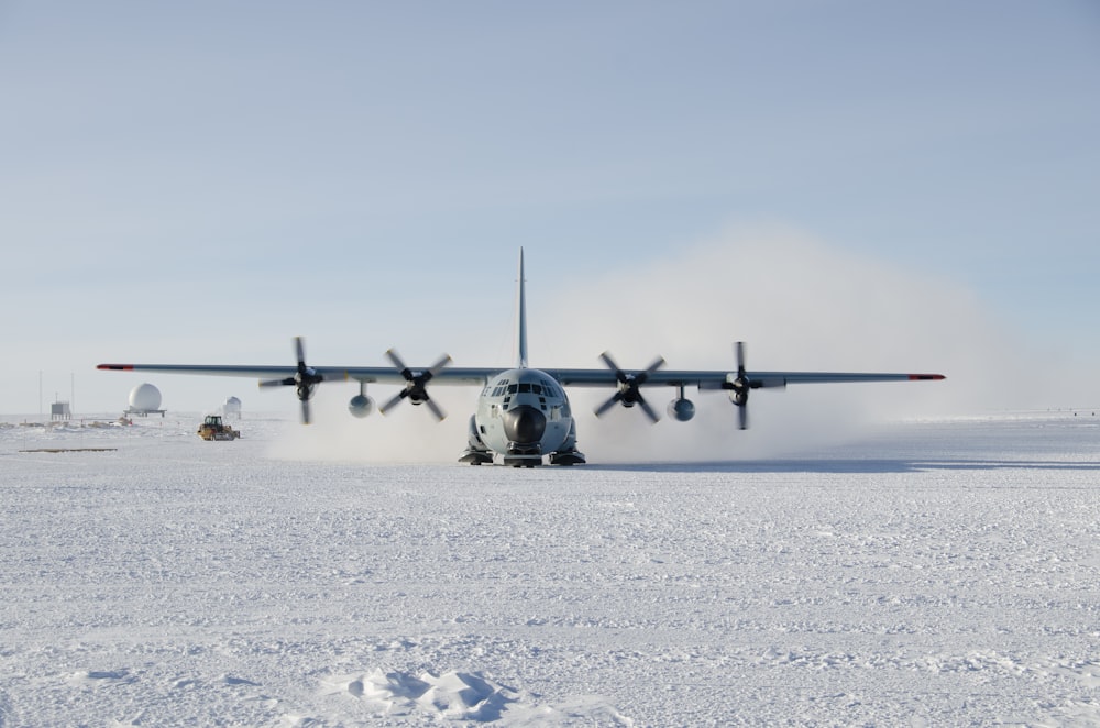 avião pousando em campo de neve durante o dia