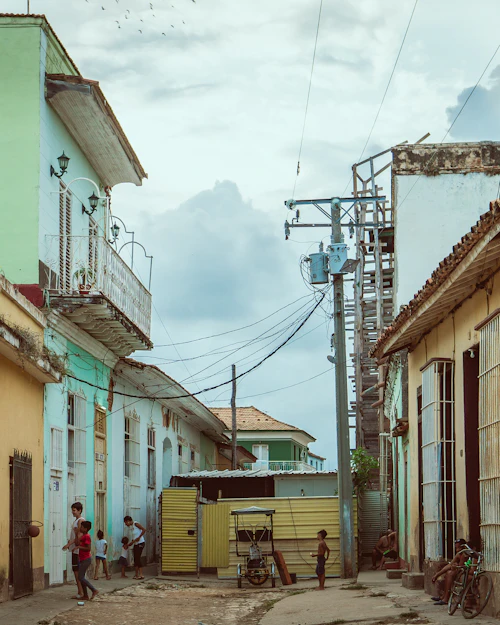 People standing near houses on a street in Trinidad, Cuba