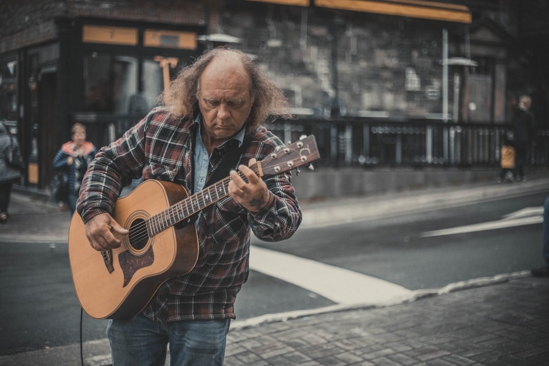 man holding guitar during daytim