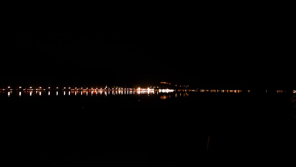 a body of water at night with lights reflecting in the water