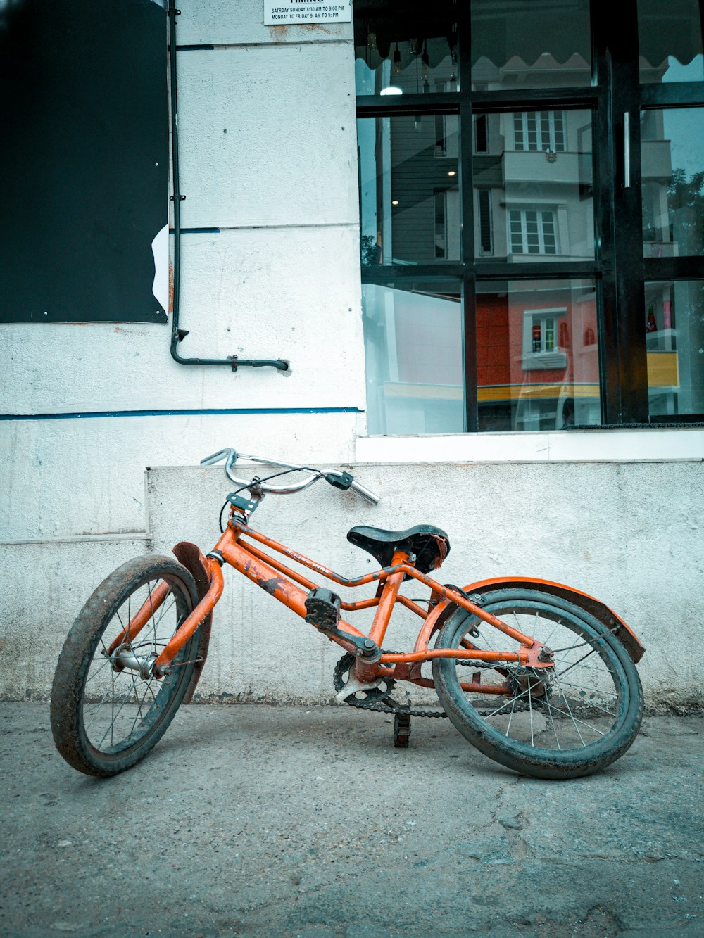 orange BMX bike beside wall