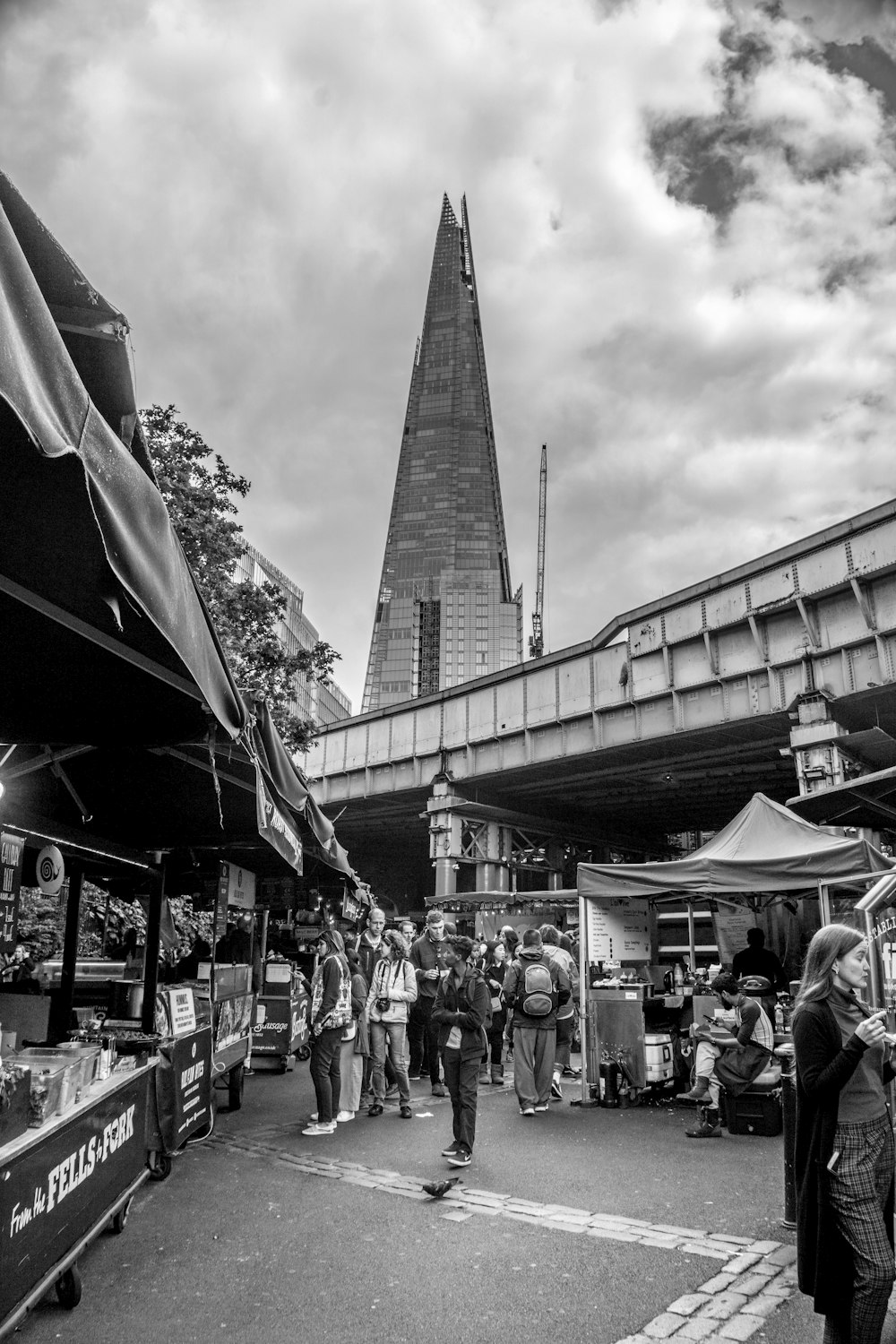 grayscale photography of people near bridge