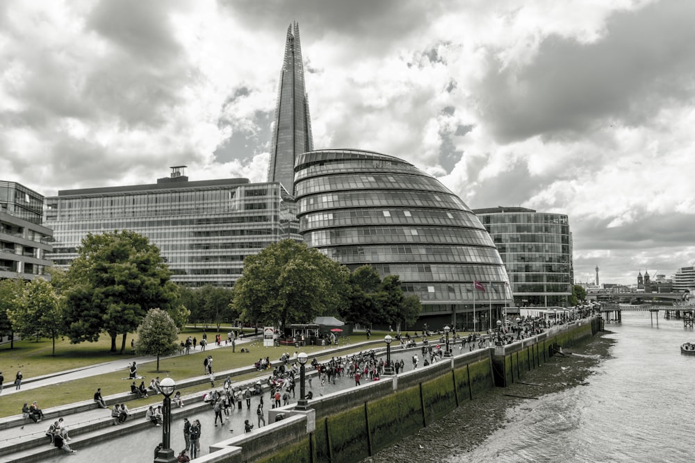 people walking near river with buildings at distance