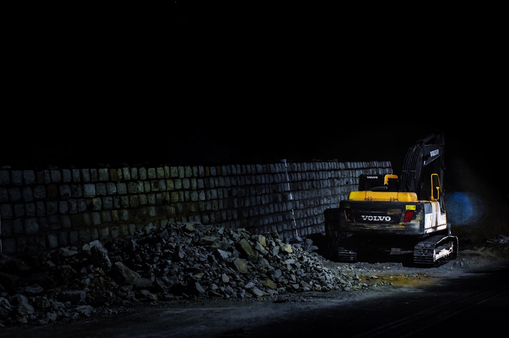 a bulldozer digging through a pile of rubble at night