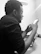 Photo of a focused technician using a tablet in front of HVAC equipment.