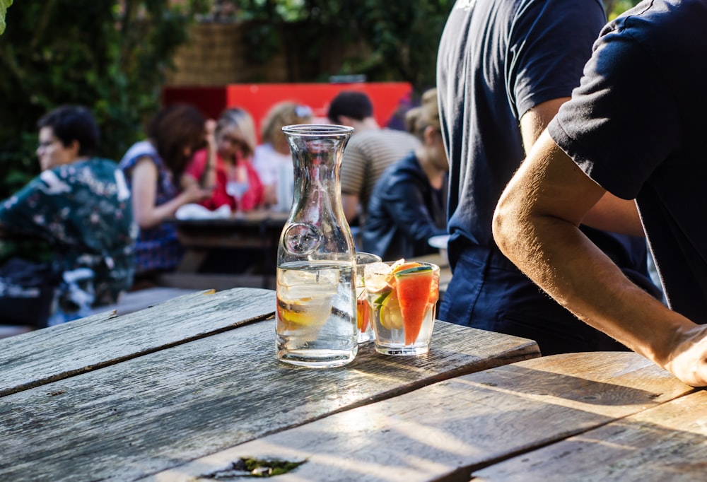 bouteille en verre transparent à travers les gens