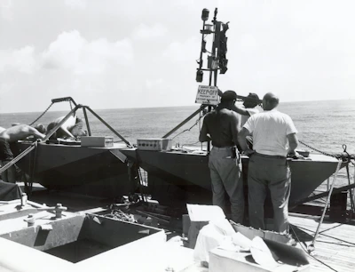 A team of marine technicians collaborating on a vessel’s deck, smiling and reviewing repair plans.
