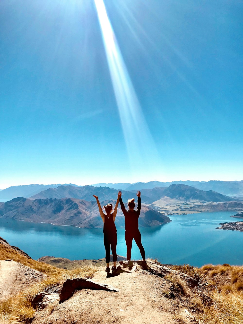 two women standing and raising hands