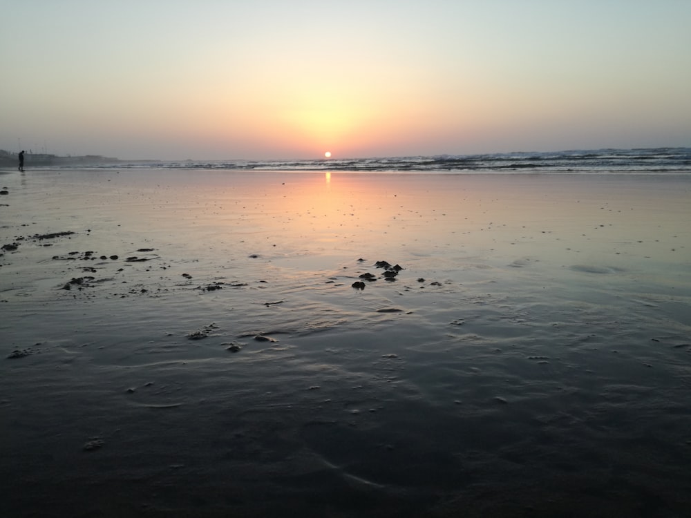 body of water across horizon during sunset