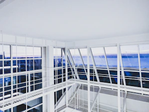 Architects reviewing detailed blueprints in a bright, minimalist studio with Hebridean skies visible through large windows.