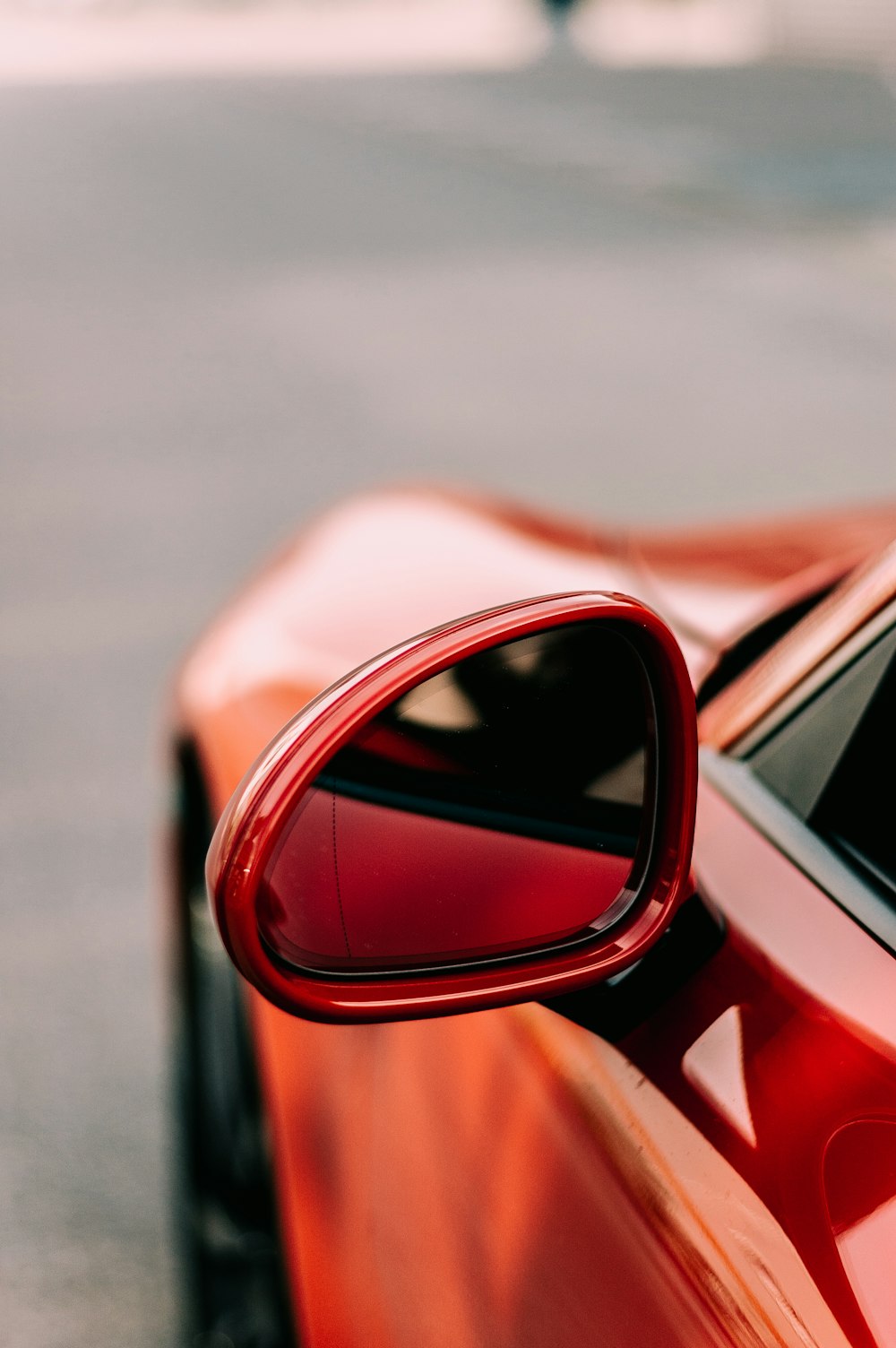 close-up photo of red vehicle wing mirror