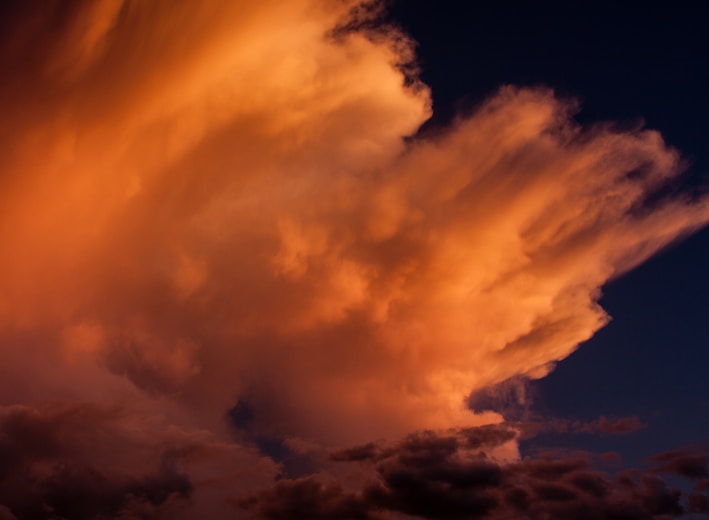 Wind blown cloud tops in the setting sun. 