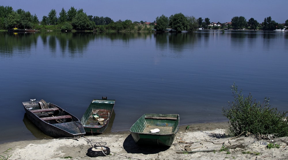 three motor boats near seashore viewing lake