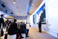 man standing beside projecting wall in front of people