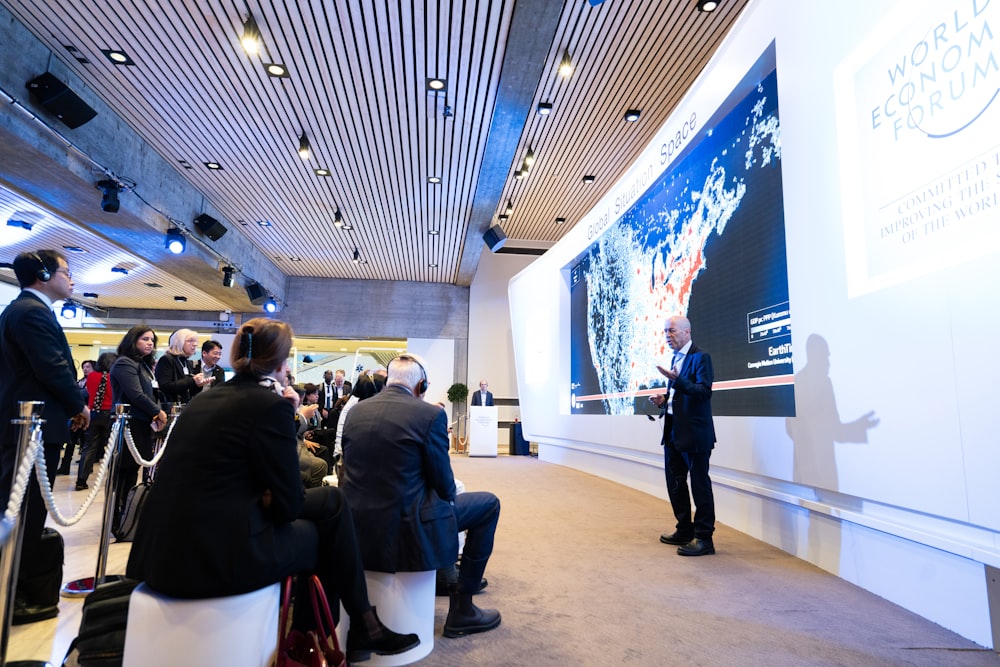 man standing beside projecting wall in front of people