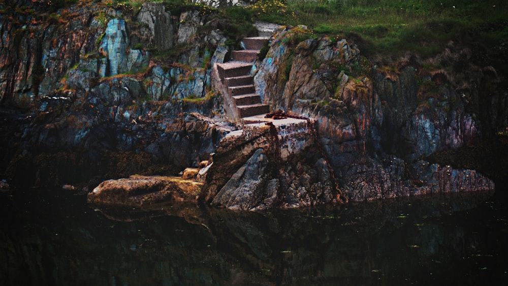 landscape photography of hill with stairs in front of body of water