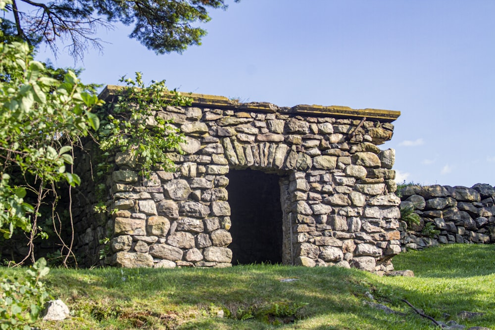 Maison en pierre brune près d’un champ vert
