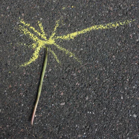 An abstract chalk drawing on pavement illustrating cosmic patterns and human connections.