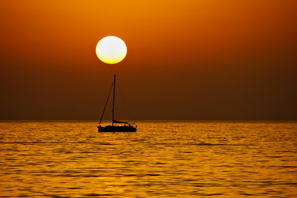 silhouette of a sailboat at sunset