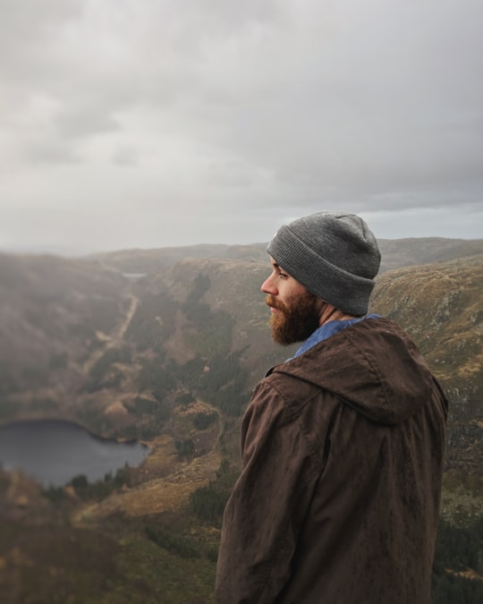 man standing and facing on lake and mountain in Byfjellene 19 Norway