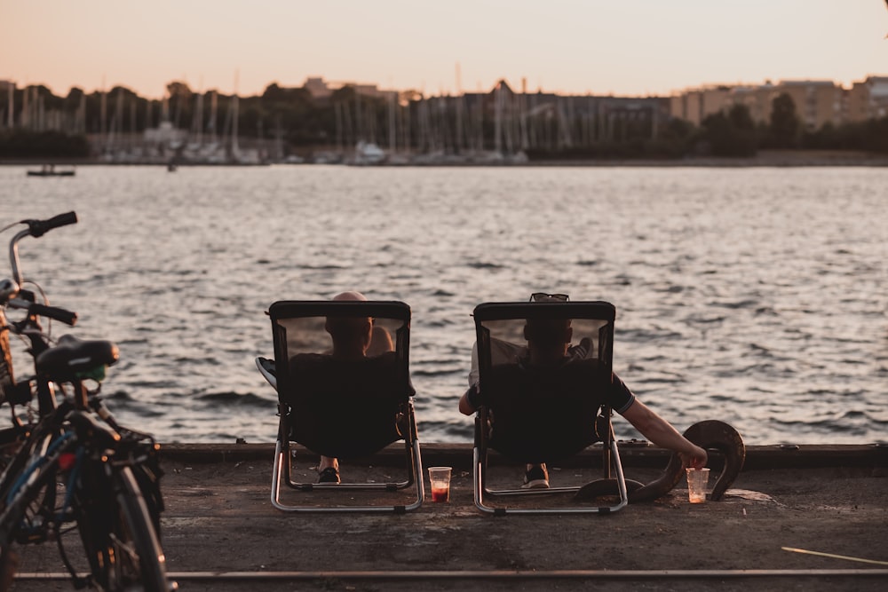 two persons sitting on deck chair