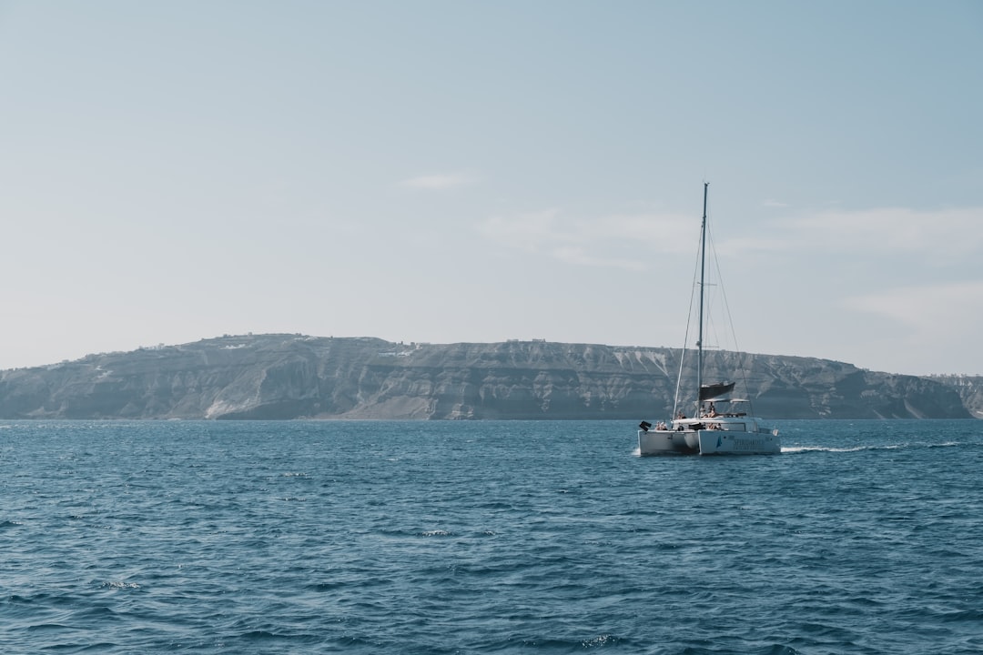 white catamaran sailboat out at sea, A catamaran in Santorini.</p></figure><p>IG: instagram.com/febiyanr