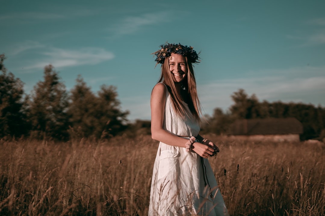 woman standing and smiling in brown wheat field