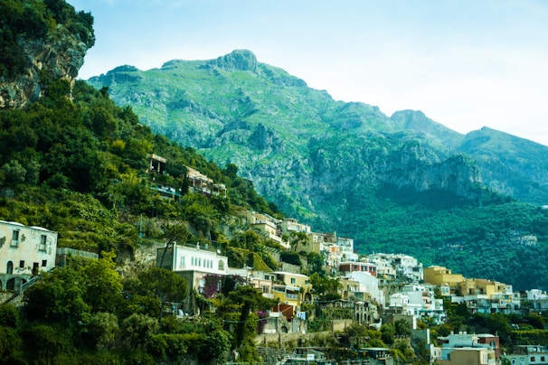 A vibrant mountain village nestled among lush green hills under a clear blue sky