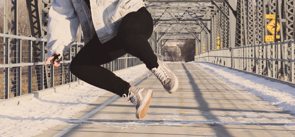 man jumping on top of bridge