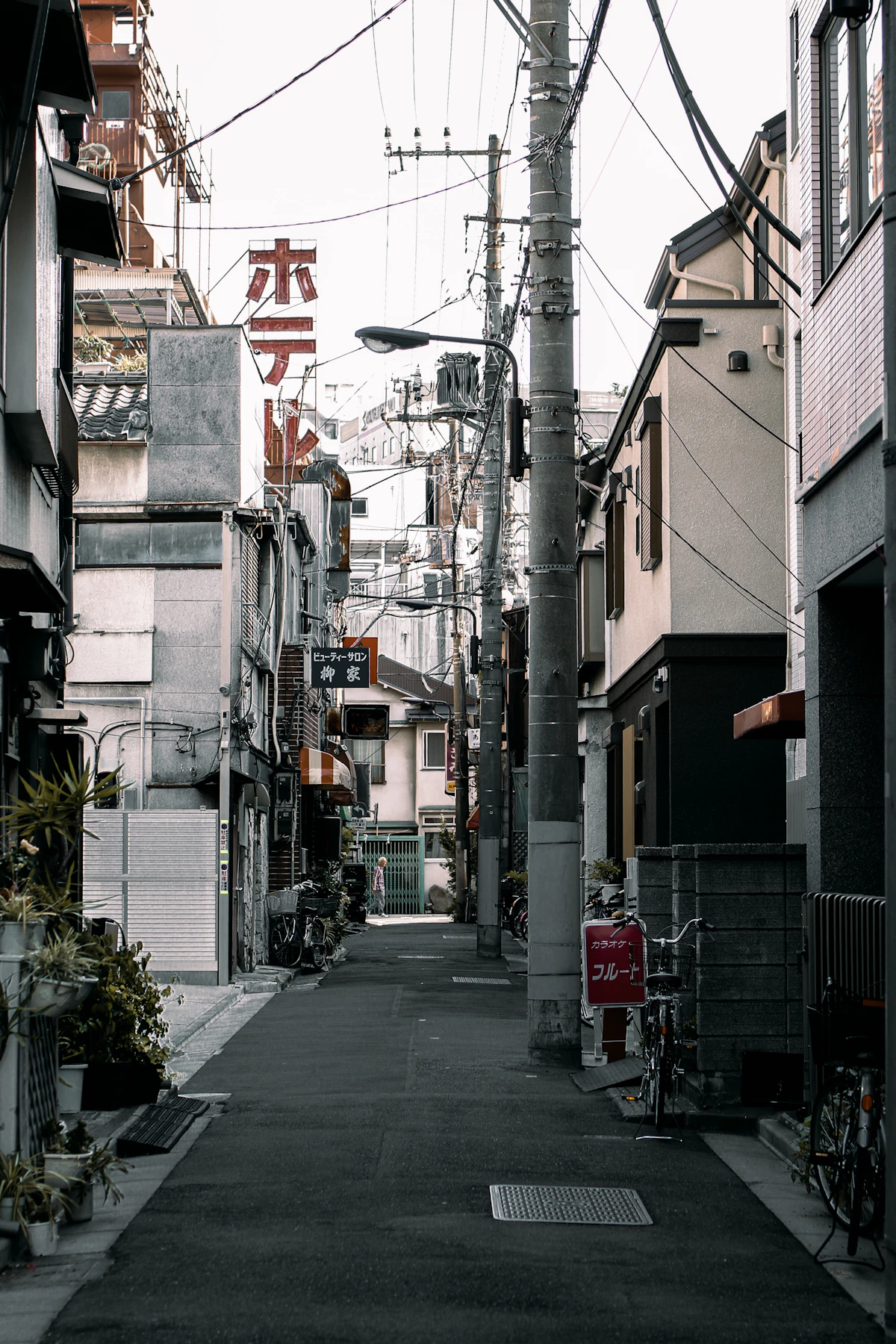 A narrow traditional street in Kyoto lined with wooden machiya buildings