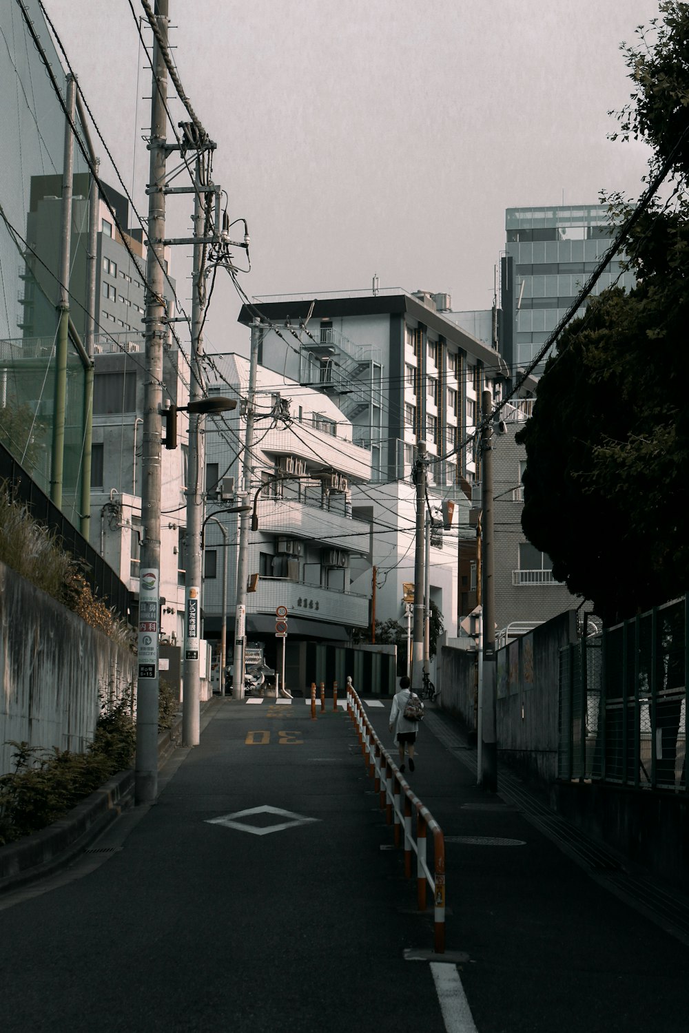 person walking on road beside rail