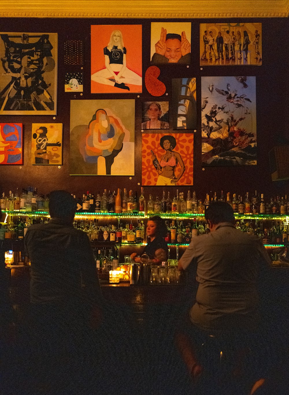 man sitting inside bar in front of bottles