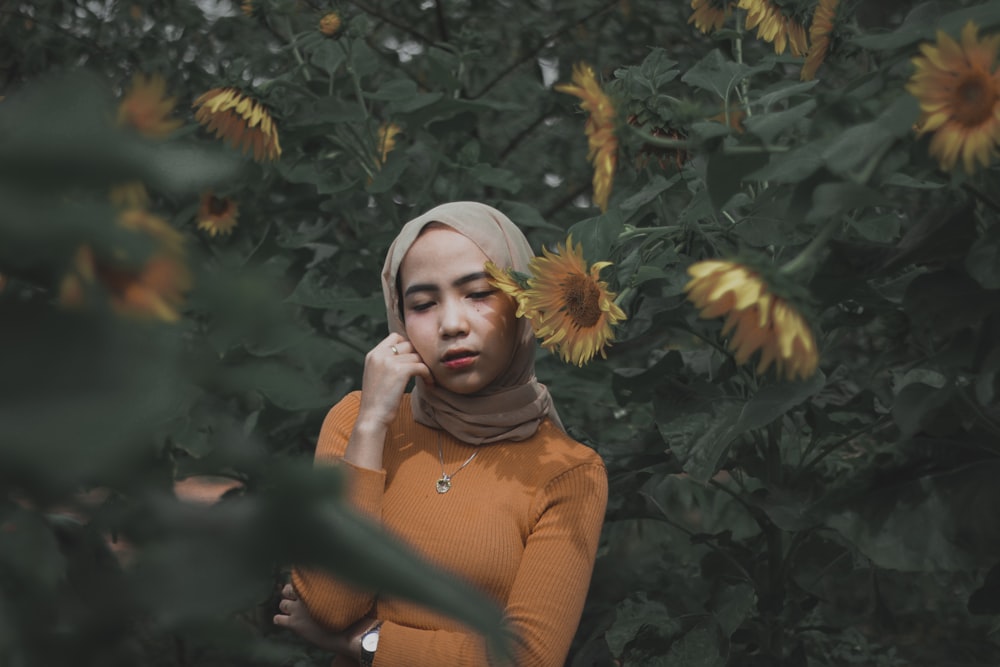 selective focus photography of woman surrounded with sunflowers