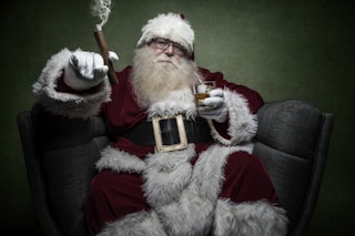 man wearing Santa Claus costume sitting on chair